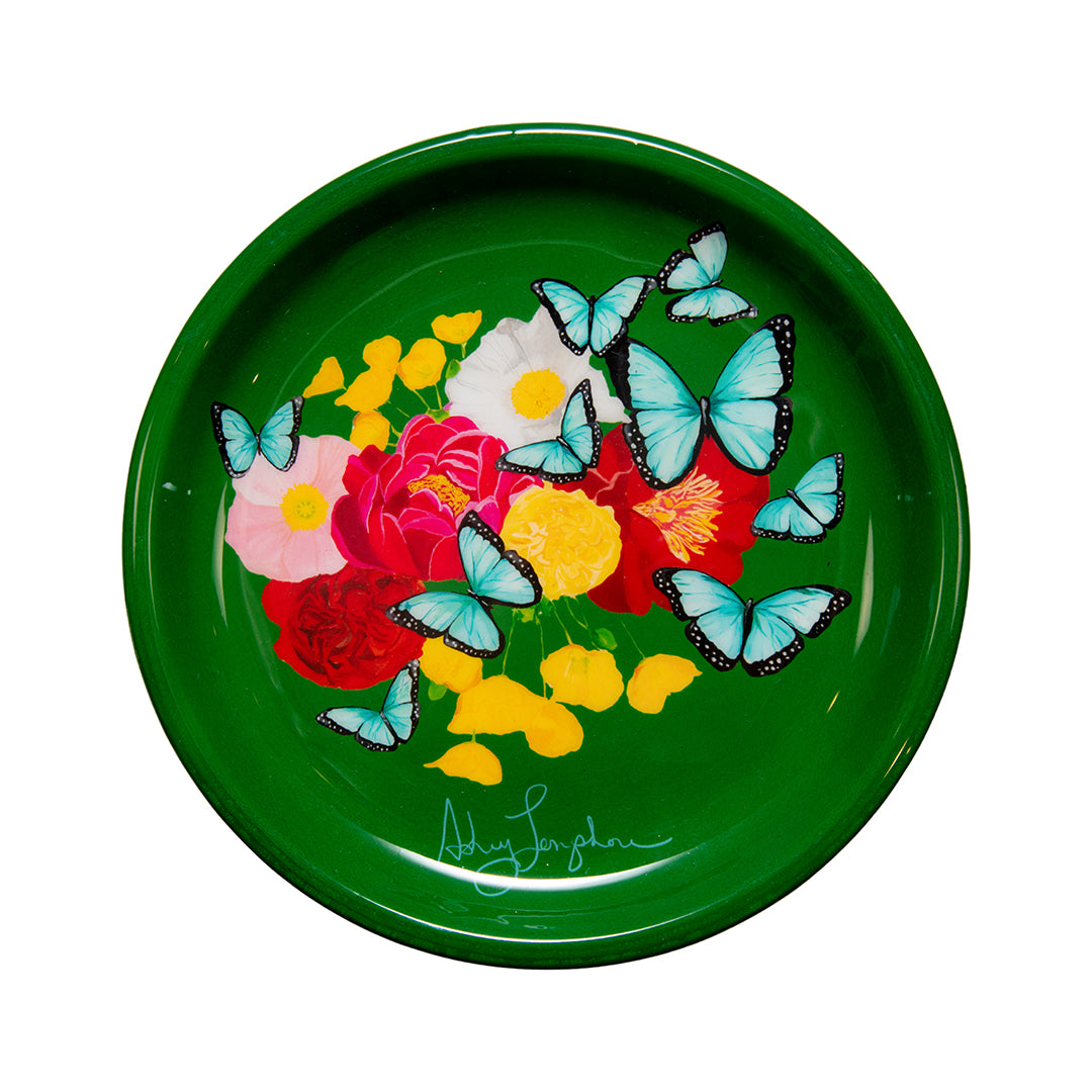 Decorative green plate with floral and butterfly design on a white background