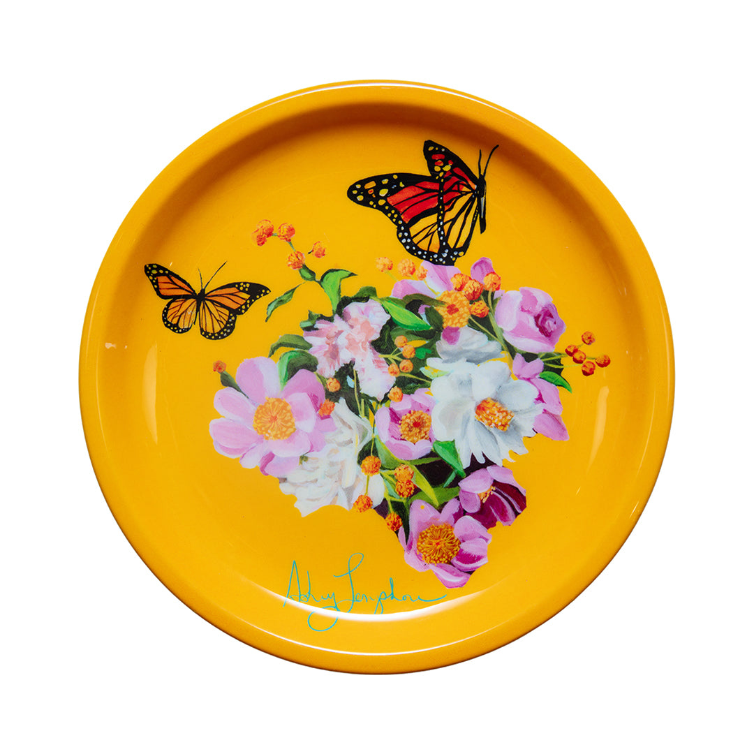 Yellow plate with floral design and butterflies on a white background