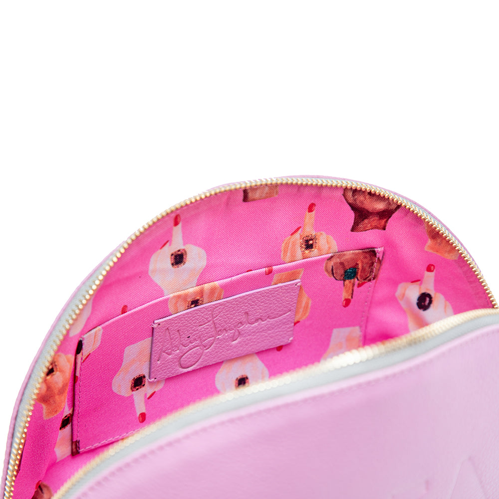 Inside view of the pouch showing bright pink fabric lining with illustrated hands giving the middle finger and a leather Ashley Longshore logo patch.