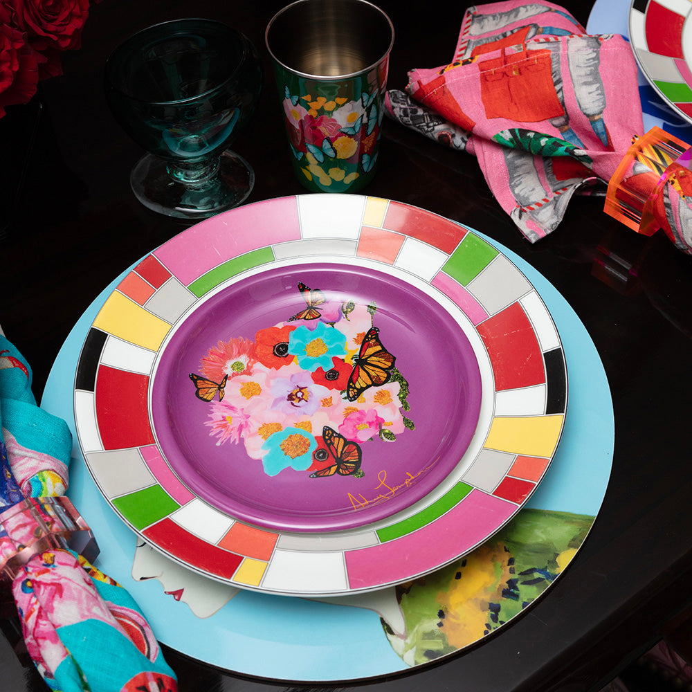 Colorful enamel plate with floral and butterfly design on a black surface