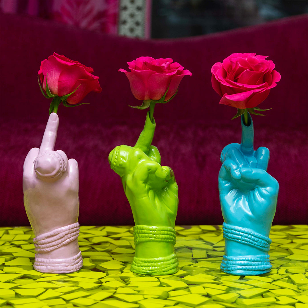 A set of three ceramic bud vases in pink, lilac, and blue colors, each shaped like a stylized hand making a 'bird' gesture.