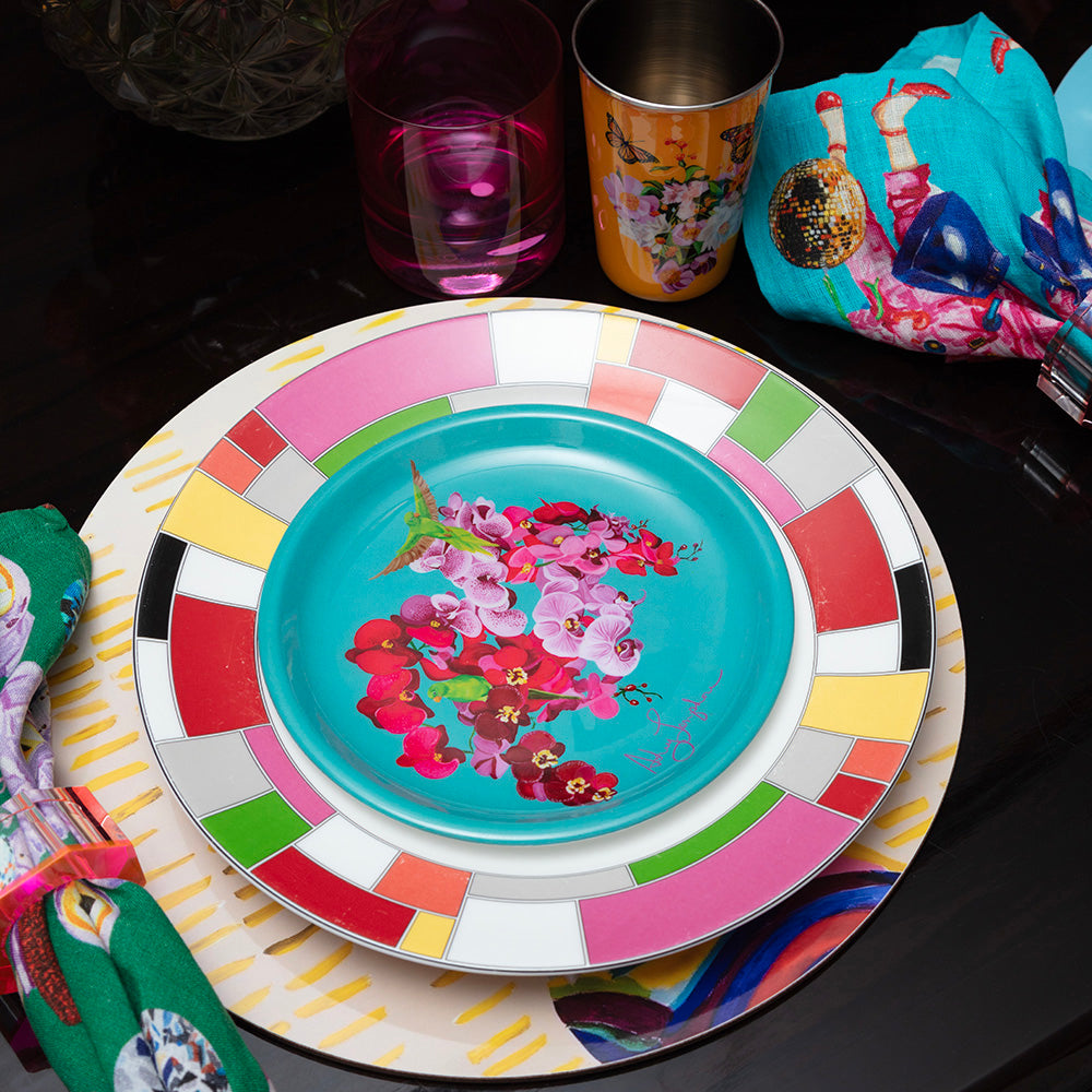 Colorful enamel plate with floral design on a dark surface