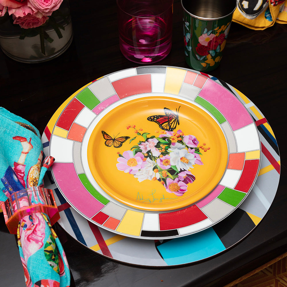 Colorful enamel plate with butterfly and floral design on a table setting.