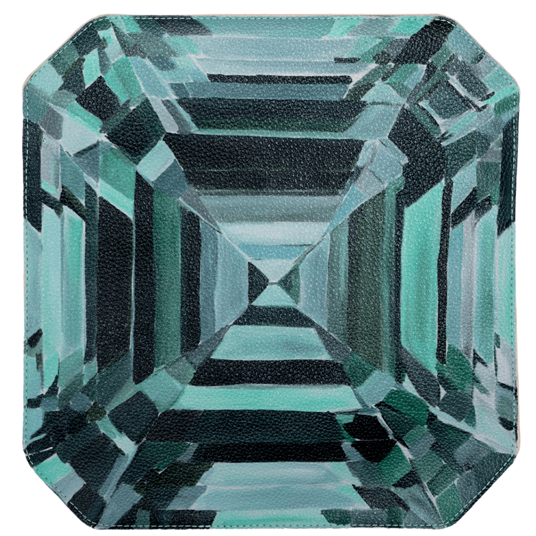 A clutch bag with a geometric emerald pattern and a contrasting zipper.